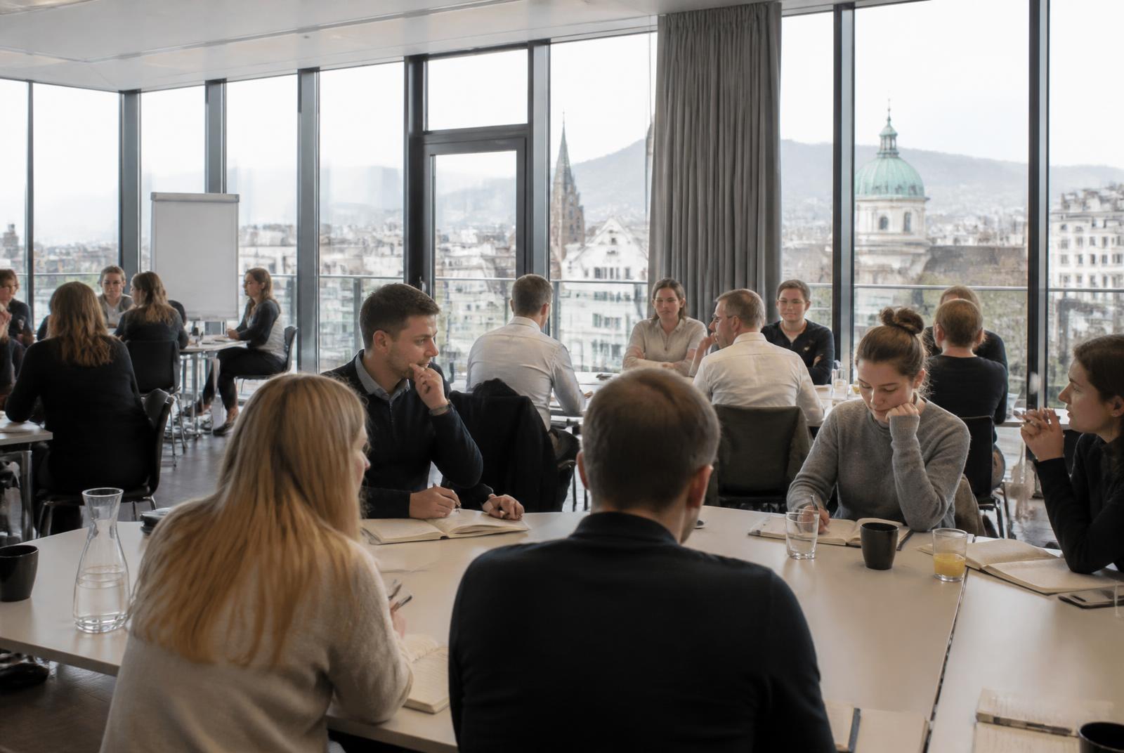 Teilnehmende an einem Seminar in einem hellen Tagungsraum